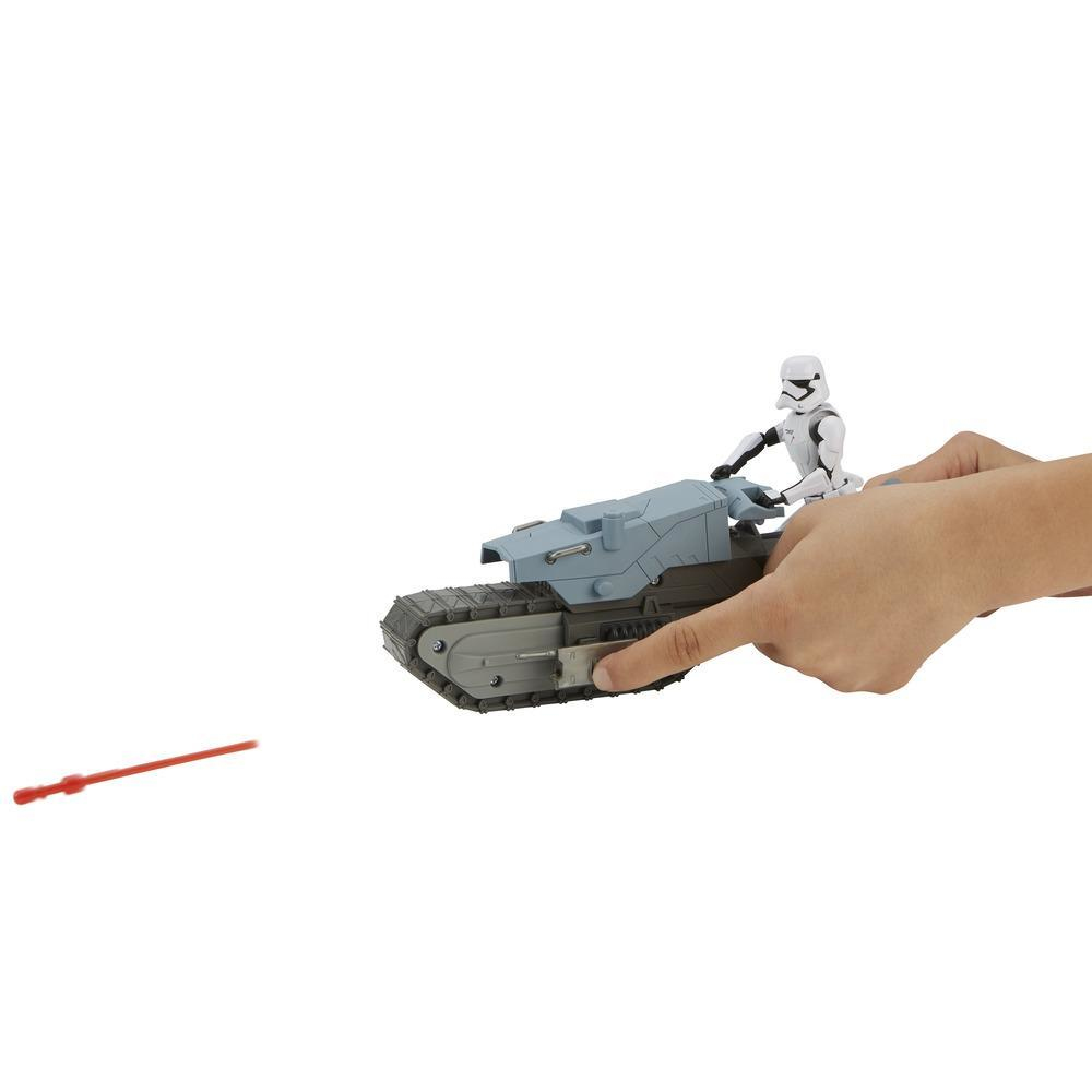Figurka Szturmowca z Gwiezdnych Wojen jadąca szarym pojazdem przypominającym czołg, z czerwonym promieniem lasera.