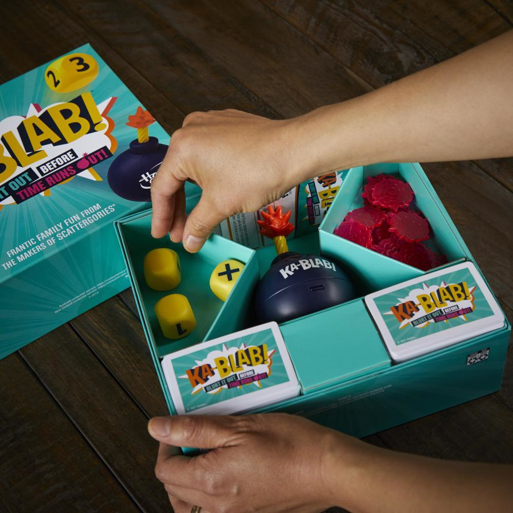 Eine Brettspielbox, in die eine Person greift. Das Spiel heißt Ka-Blab!