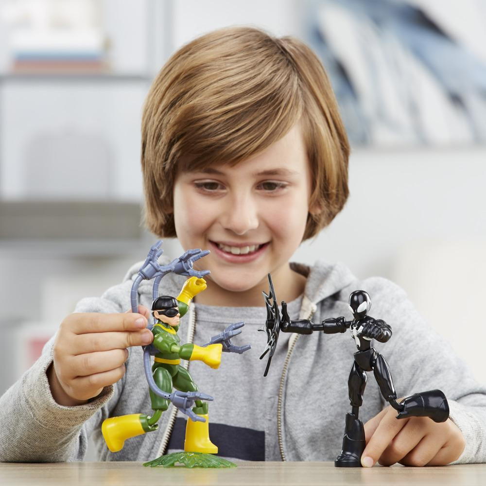 Chłopiec bawi się figurkami Spider-Mana i Doktora Octopusa. Chłopiec się uśmiecha.