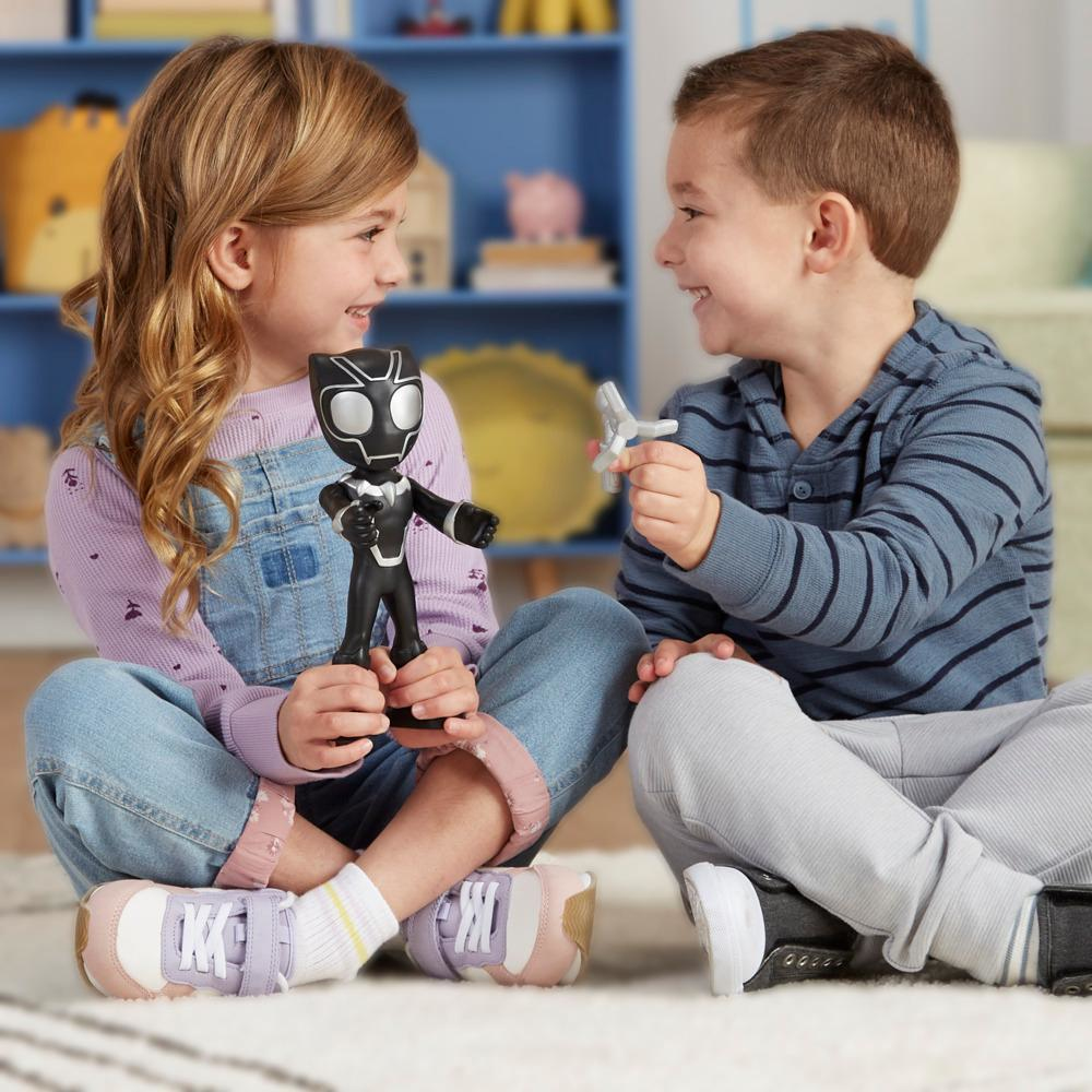Due bambini che giocano con i giocattoli. Uno tiene una figura di Pantera Nera, l'altro un aereo giocattolo, sorridendo.