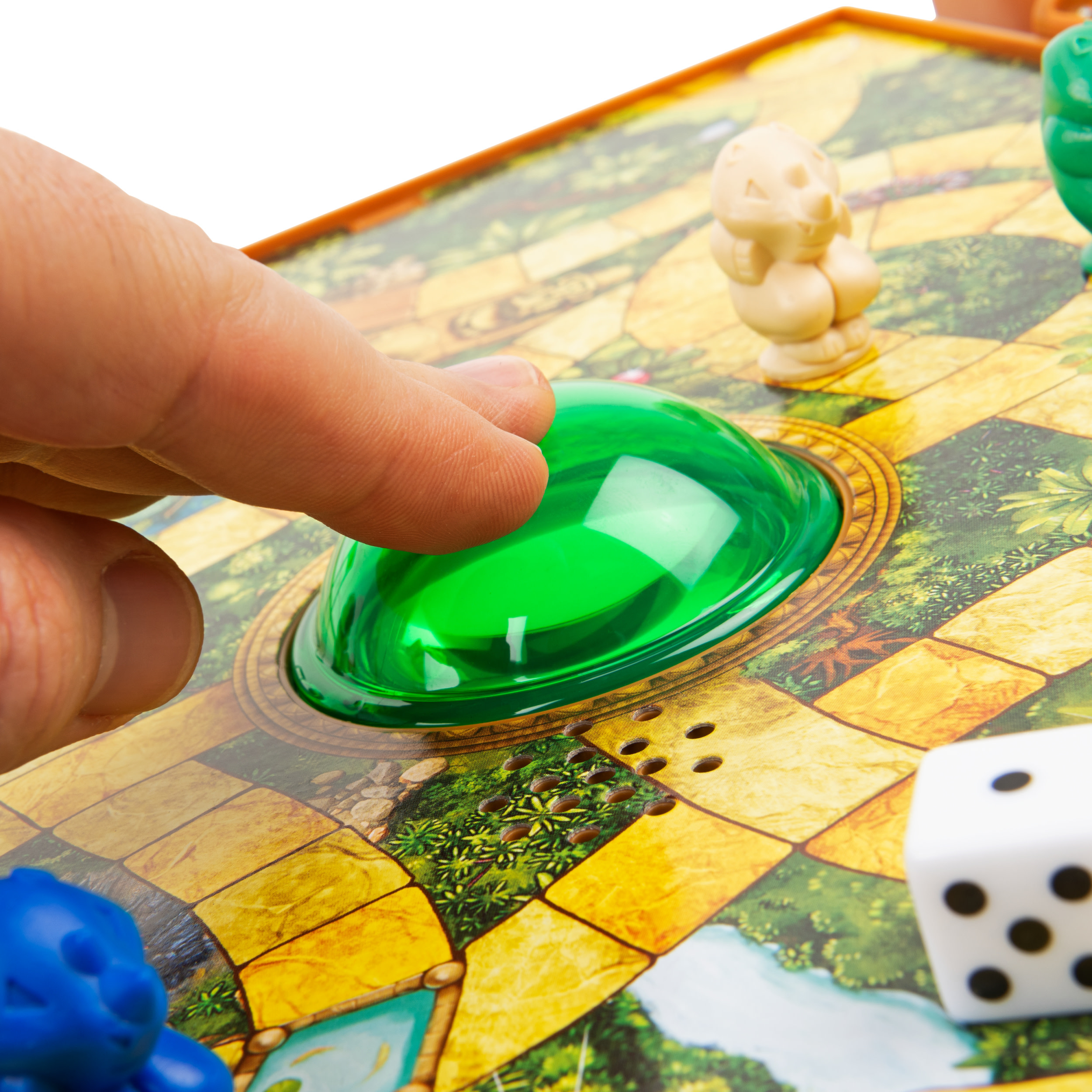 Eine Hand drückt einen großen grünen Knopf auf einem farbenfrohen Spielbrett mit Spielfiguren und Würfeln.