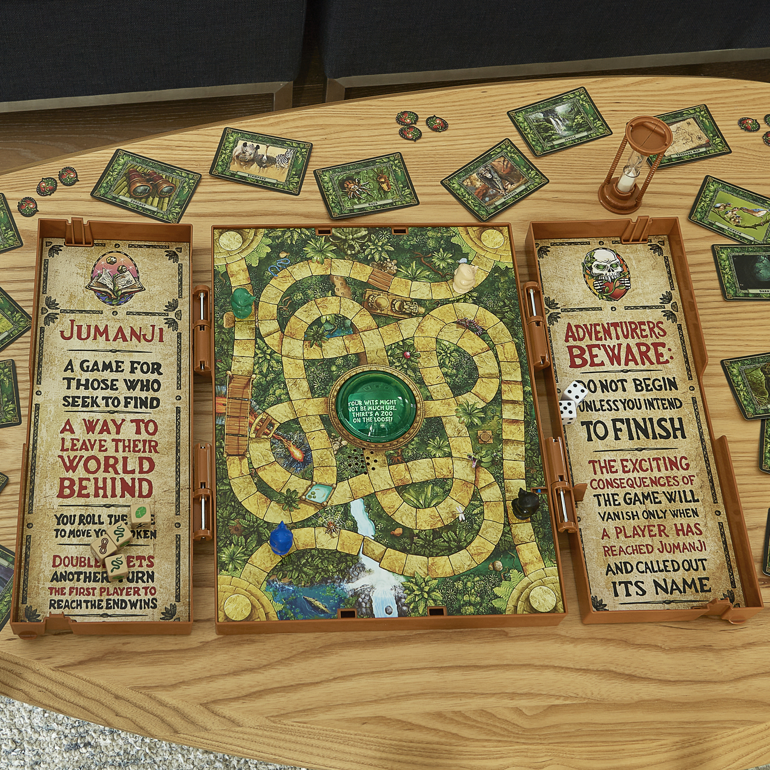 Jumanji-Brettspiel auf einem Holztisch aufgebaut. Spielbrett ist geöffnet und von Karten umgeben.