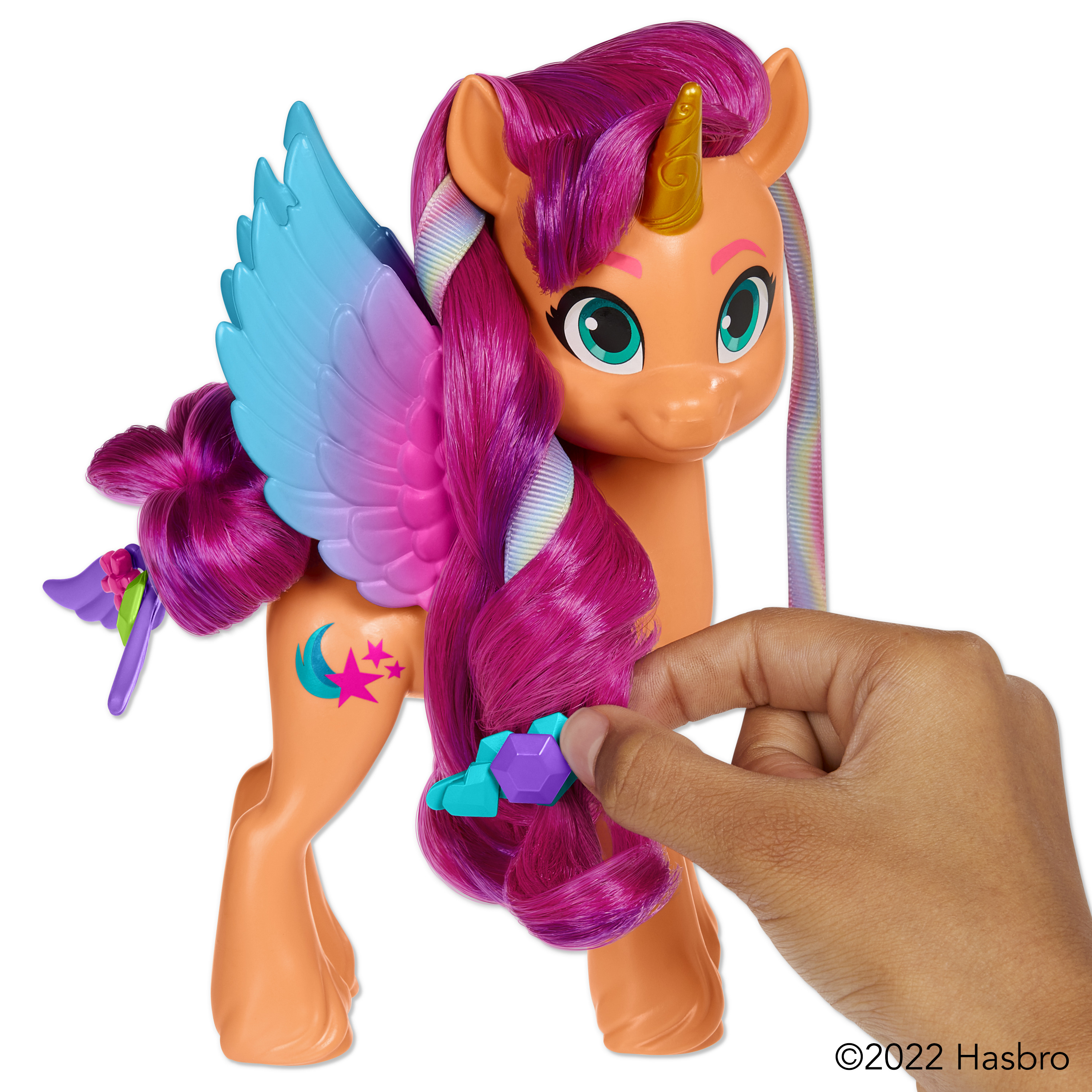 Un juguete My Little Pony con una mano sosteniendo el pelo. El pony tiene alas.