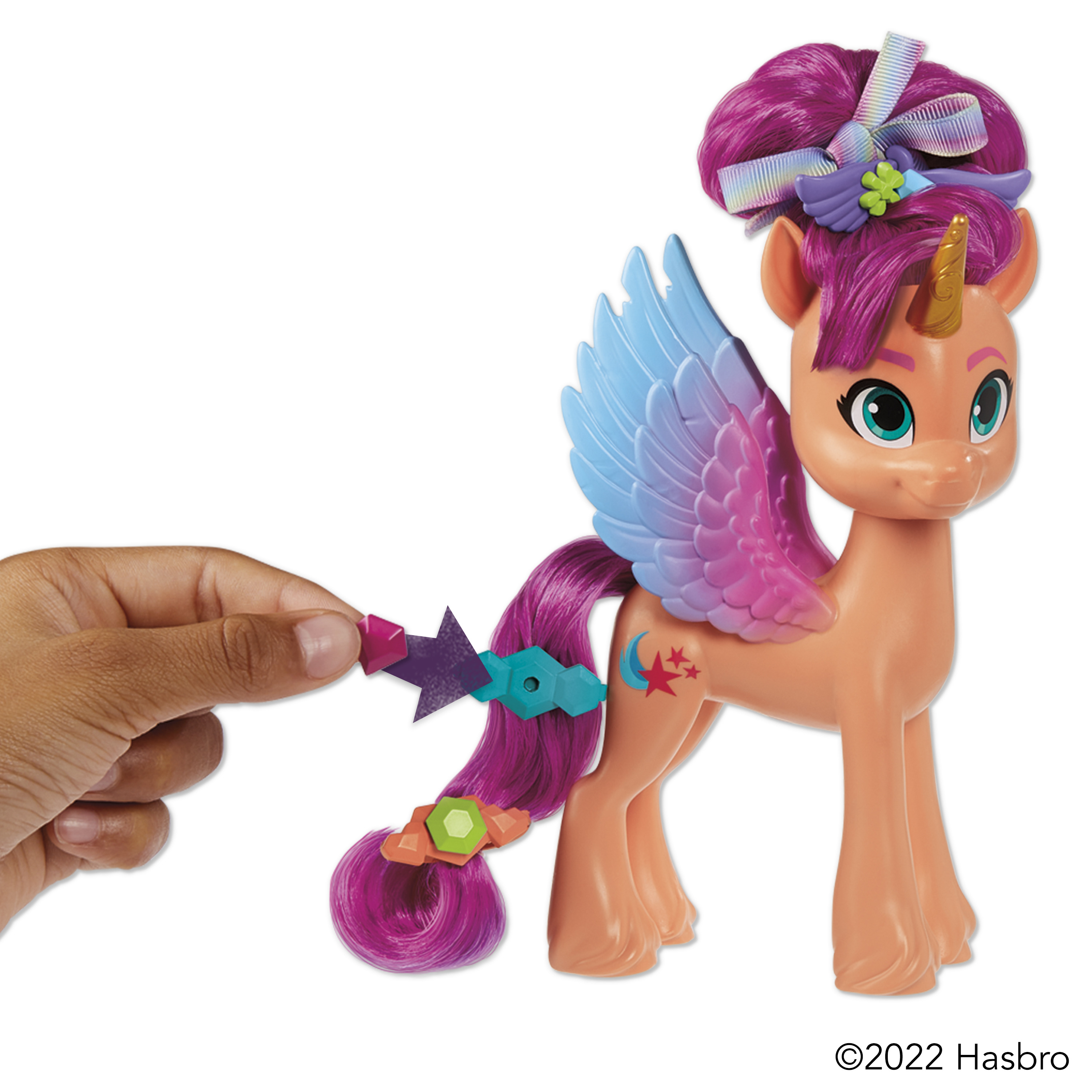Un juguete My Little Pony, un pony pegaso, con pelo y alas rosas, sostenido por una mano.