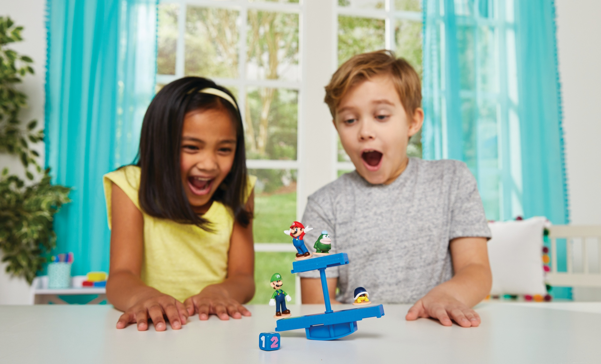 Dwoje dzieci, dziewczyna i chłopiec, z entuzjazmem grają w grę równoważną z motywem Mario.