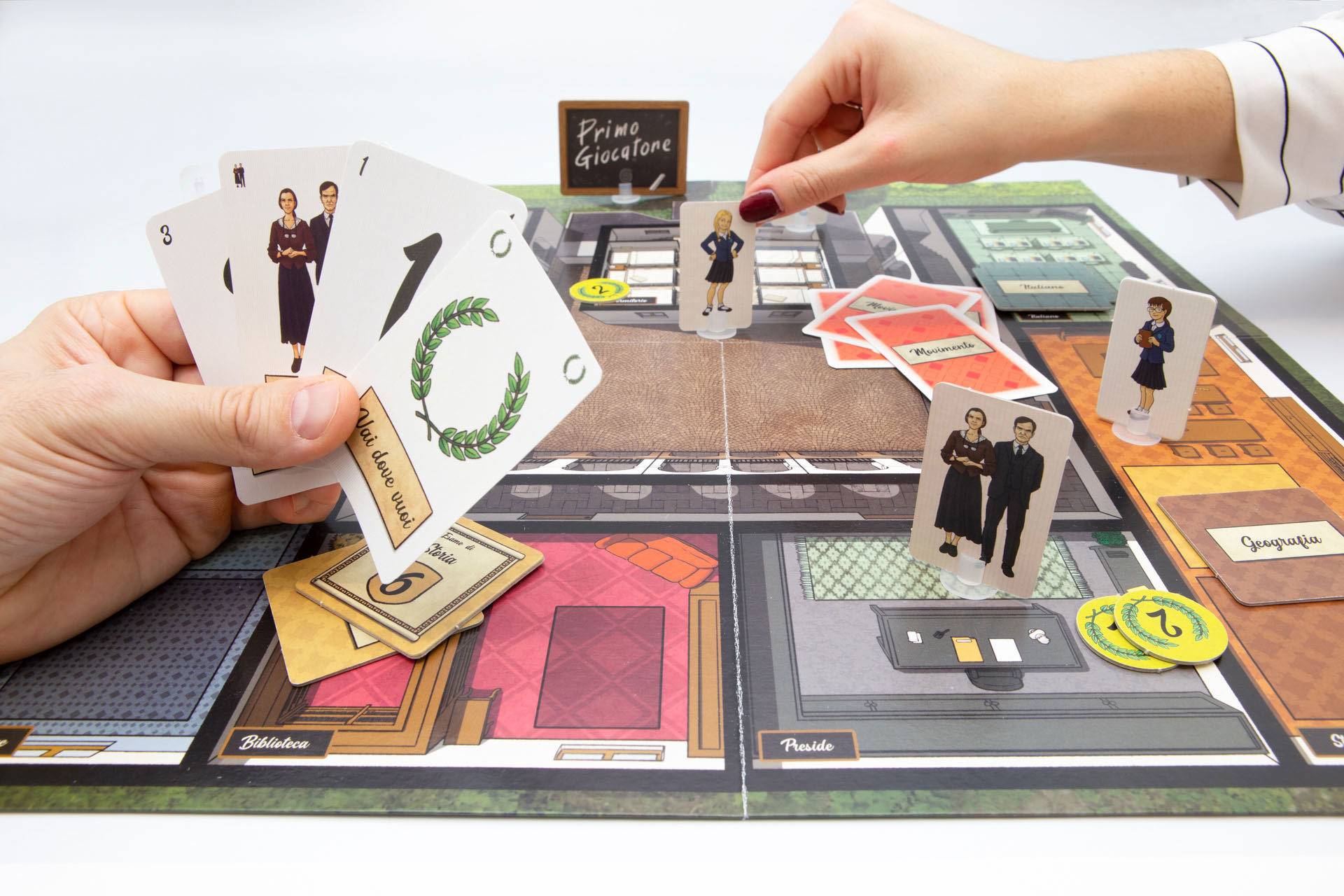 Zwei Personen spielen ein Brettspiel mit Karten und Figuren auf einem braunen Brett mit Räumen.