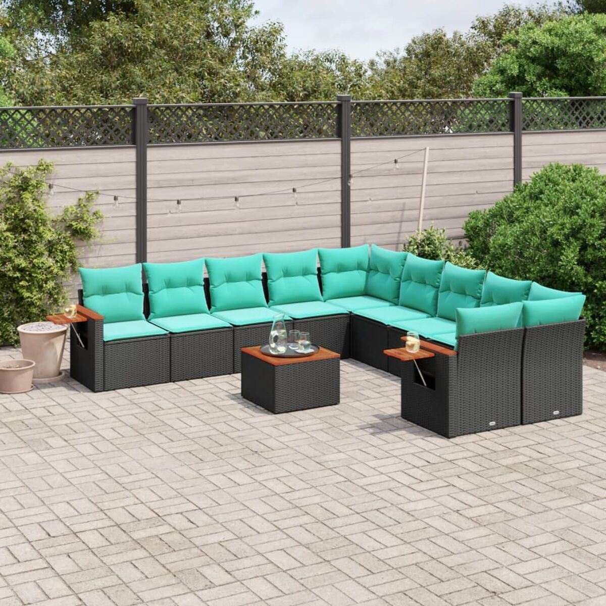 Outdoor-Ecksofa mit türkisfarbenen Kissen und einem Couchtisch auf einer Terrasse.