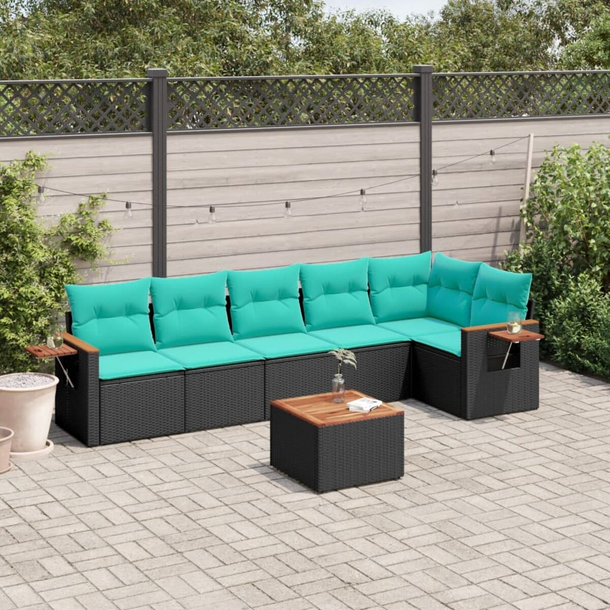 Outdoor-Ecksofa mit türkisfarbenen Kissen und Holzarmlehnen, mit einem kleinen Tisch.