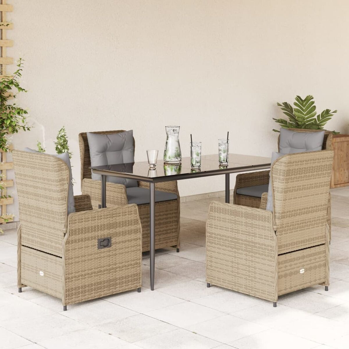 Terrassenmöbel im Freien. Korbstühle und ein Tisch. Glasplatte, graue Kissen, heller Hintergrund.