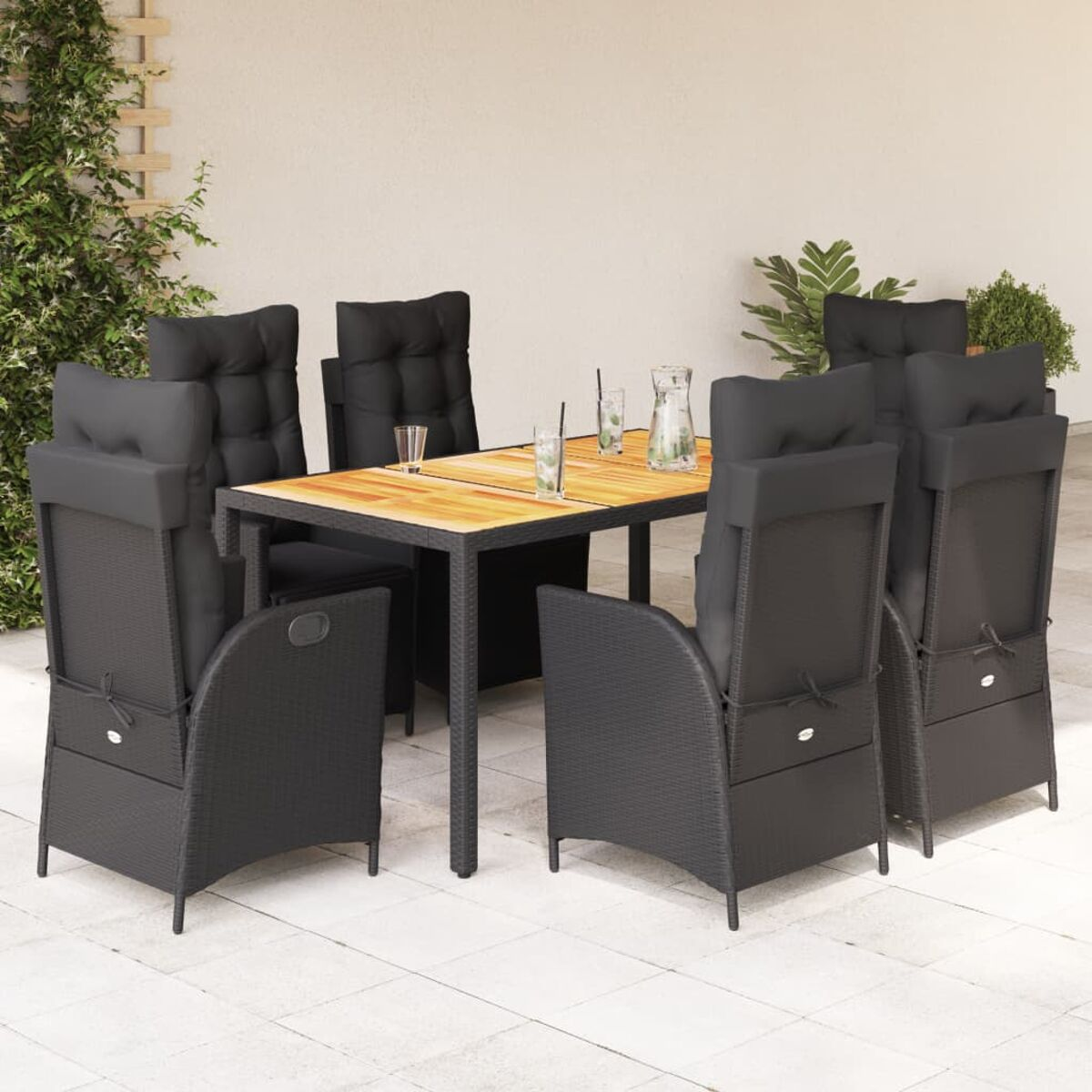 Set da pranzo all'aperto con sei sedie nere, un tavolo in legno e cuscini. Piante sullo sfondo.