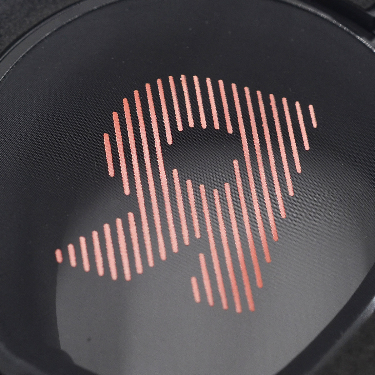 Close-up van een zwarte headset met een rood, gestileerd logo op de oorschelp.