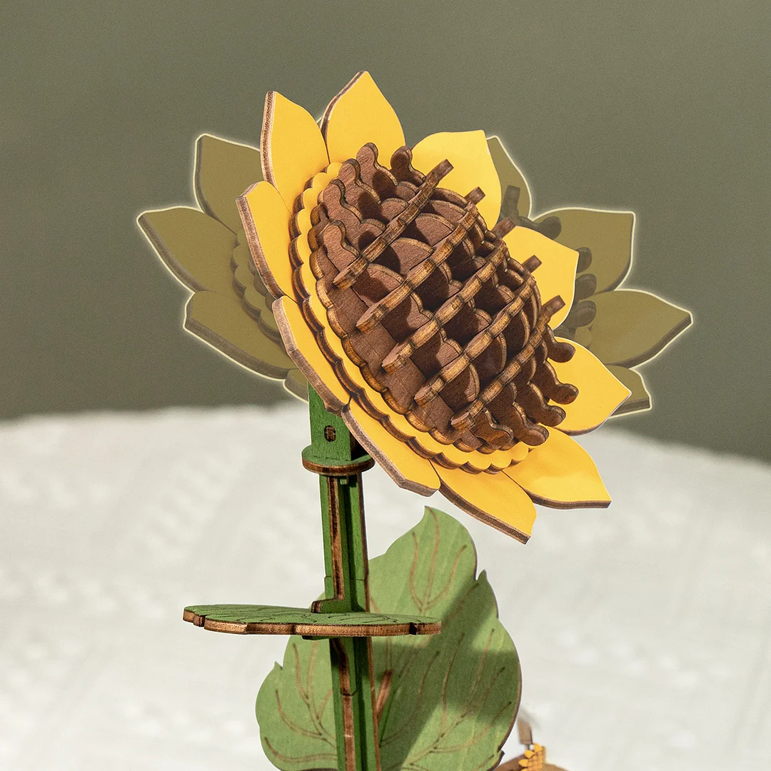 Houten zonnebloemmodel met gele bloemblaadjes, bruin centrum, groene stengel en blad.