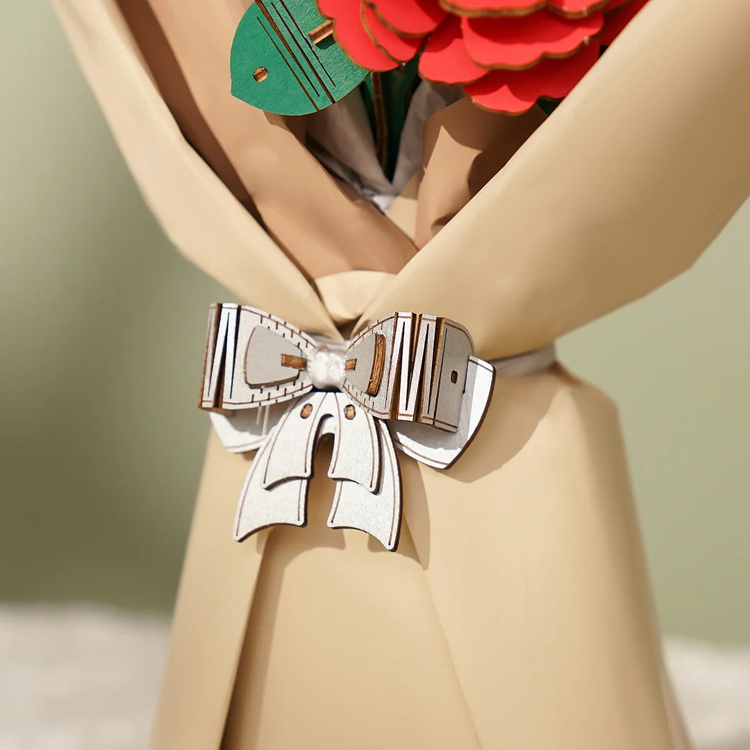 Close-up van een houten strik op een boeket, rode bloemen en andere elementen zijn zichtbaar.