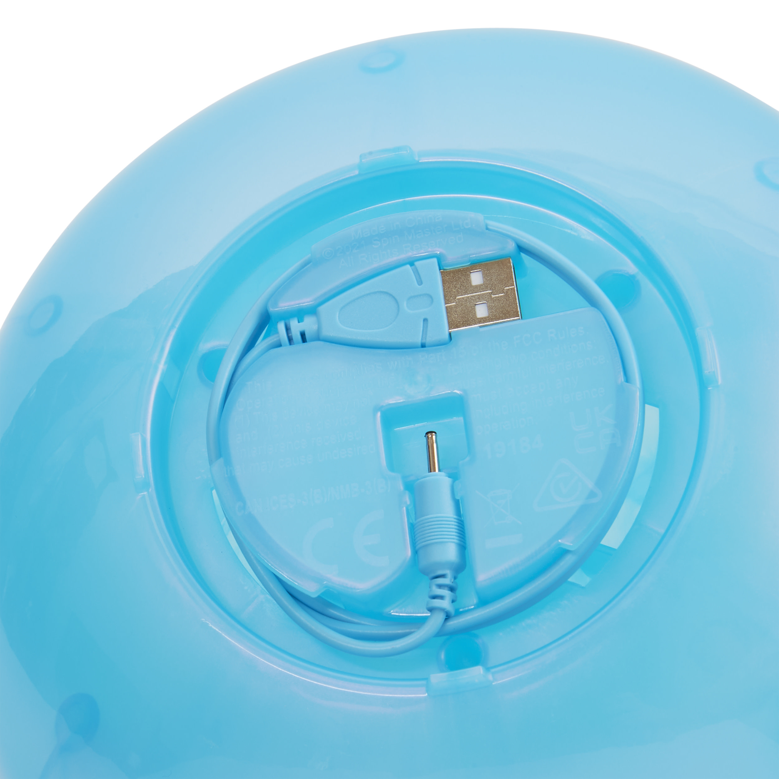 Zbliżenie na spód jasnoniebieskiej zabawki. Widoczny jest port USB i inne wejścia.