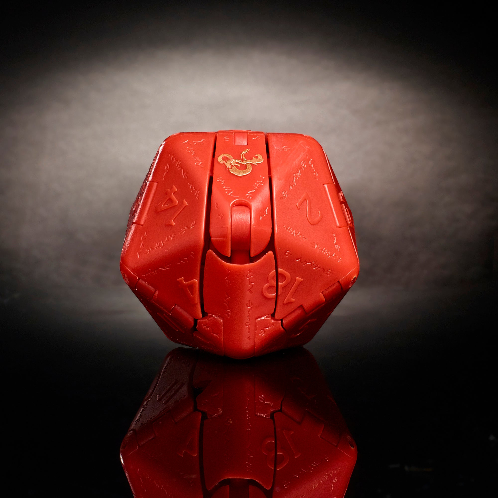 Czerwona kostka D20 z wygrawerowanymi numerami i logo D&D na odblaskowej powierzchni.