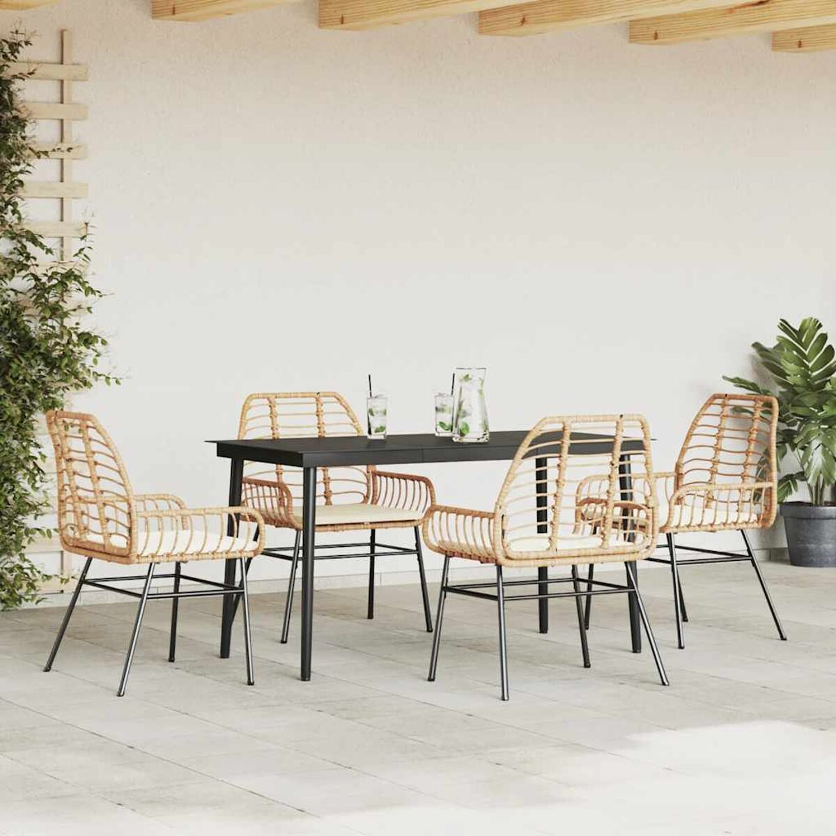 Terrassenset mit vier Stühlen und einem Tisch. Stühle und Tisch sind aus gewebtem Material. Es gibt eine grüne Pflanze.