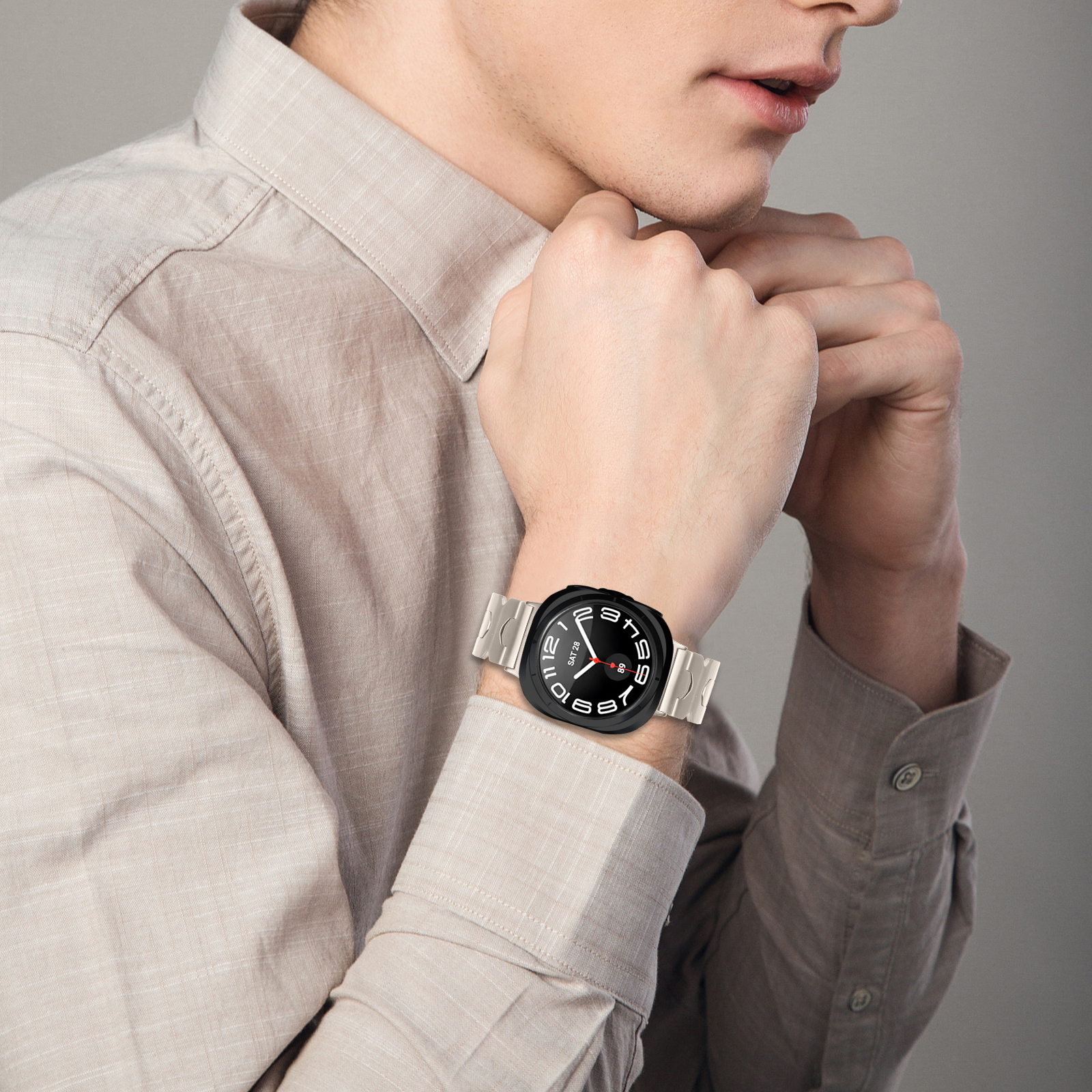 Polso di uomo con orologio nero. L'orologio è su una camicia chiara.
