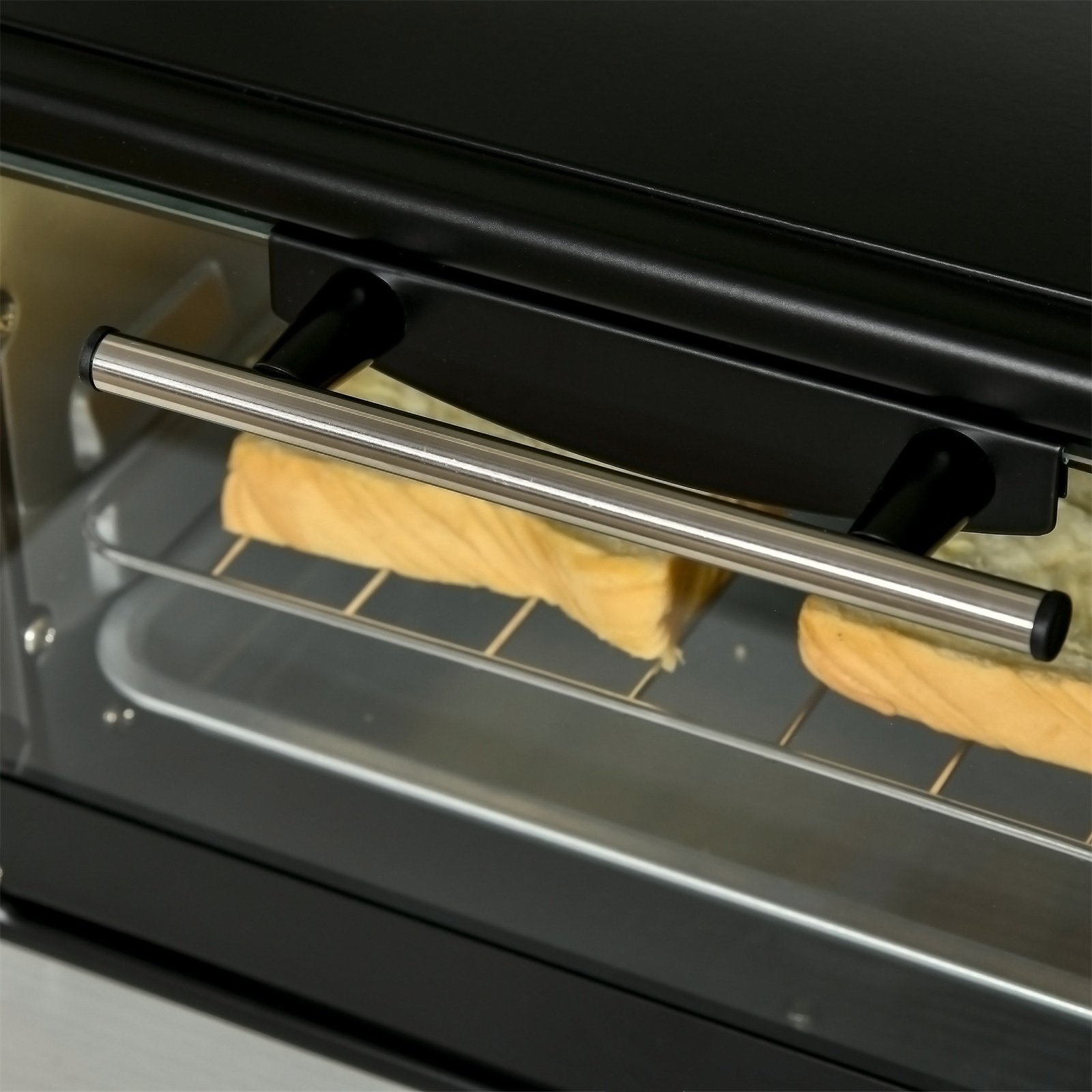 Nahaufnahme eines schwarzen Toasterofens mit Brot auf dem Rost.
