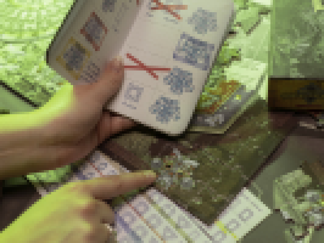Hand einer Person, die auf Anweisungen in einem Heft zeigt. Andere Papiere verstreut.