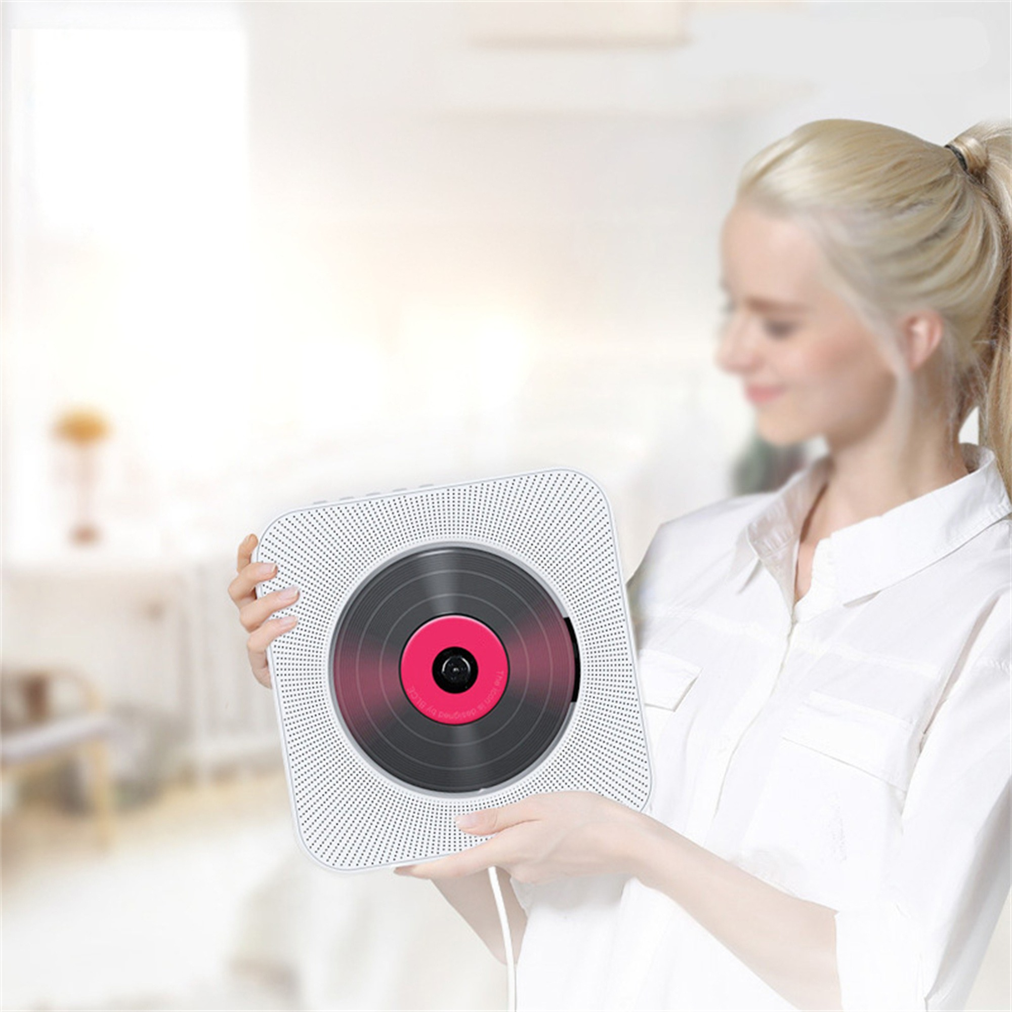 Eine Frau hält einen weißen CD-Player. Der Player hat ein Vinyl-Schallplatten-Design.