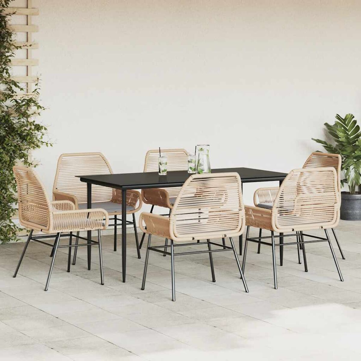 Terrassenszene: schwarzer Tisch, beige Stühle, Pflanzen und eine weiße Wand.