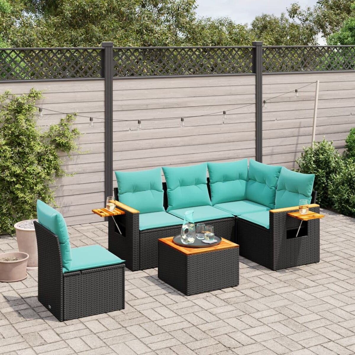 Un set da patio esterno con divano, sedia e tavolo, tutti con cuscini color verde acqua e telai neri.