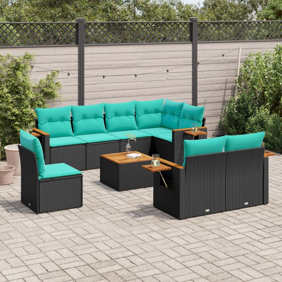 Set di mobili da esterno con divano angolare, sedia e tavolo, tutto in rattan nero con cuscini turchesi.