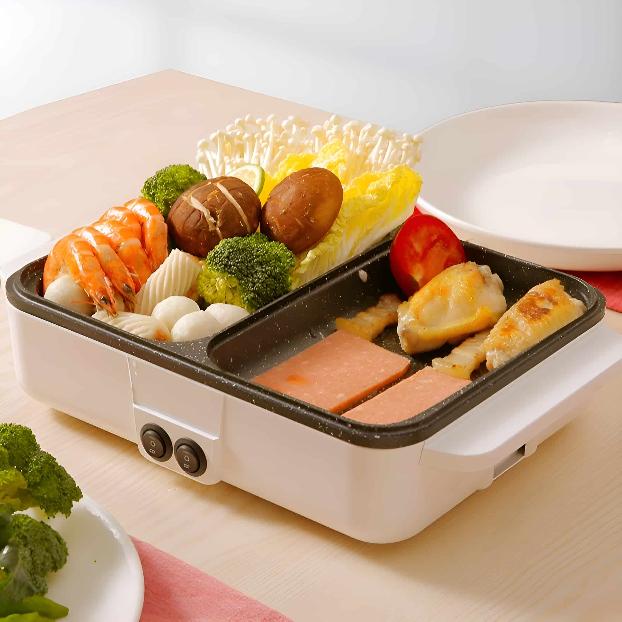 Weißer und schwarzer tragbarer Grill mit Essen: Garnelen, Gemüse und Fleisch.