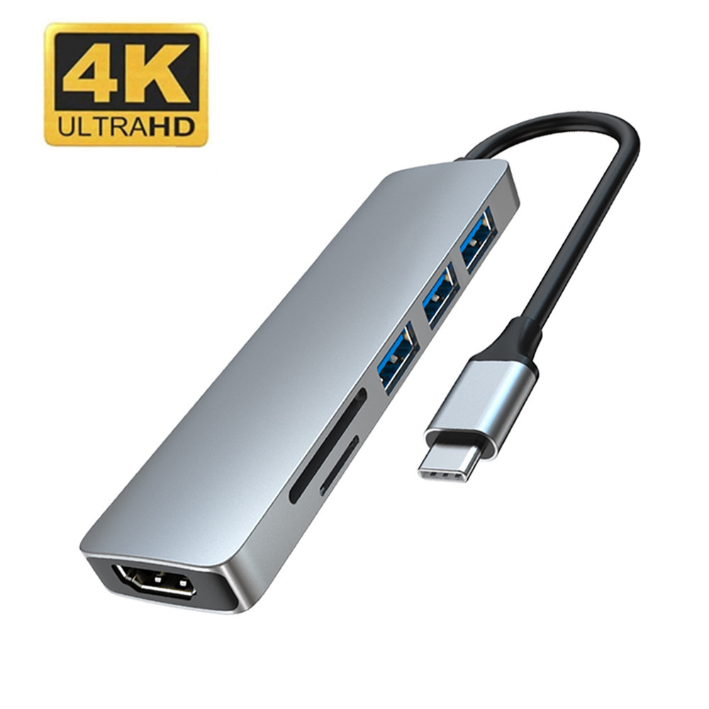 Ein silberner USB-Hub mit HDMI- und USB-Anschlüssen und einem schwarzen Kabel.