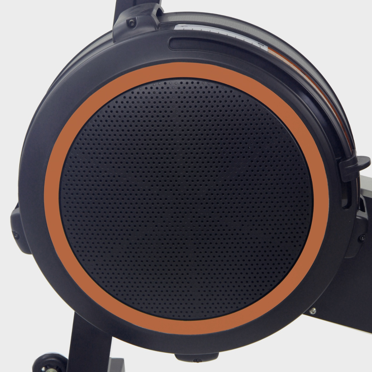 Rowing machine's flywheel. Black, orange accents, circular design.