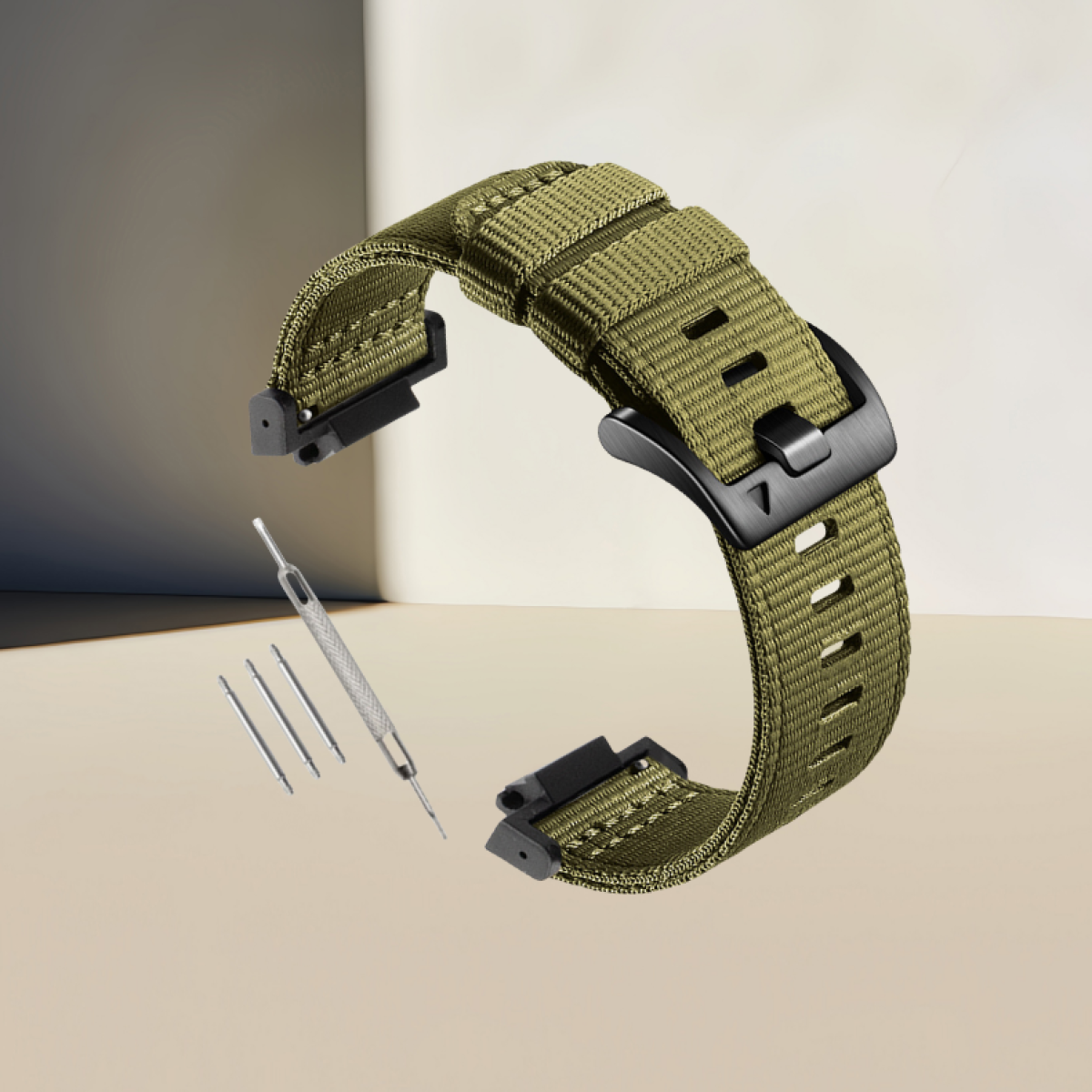 Grünes Uhrenarmband mit schwarzer Schnalle und Werkzeug auf beiger Oberfläche.