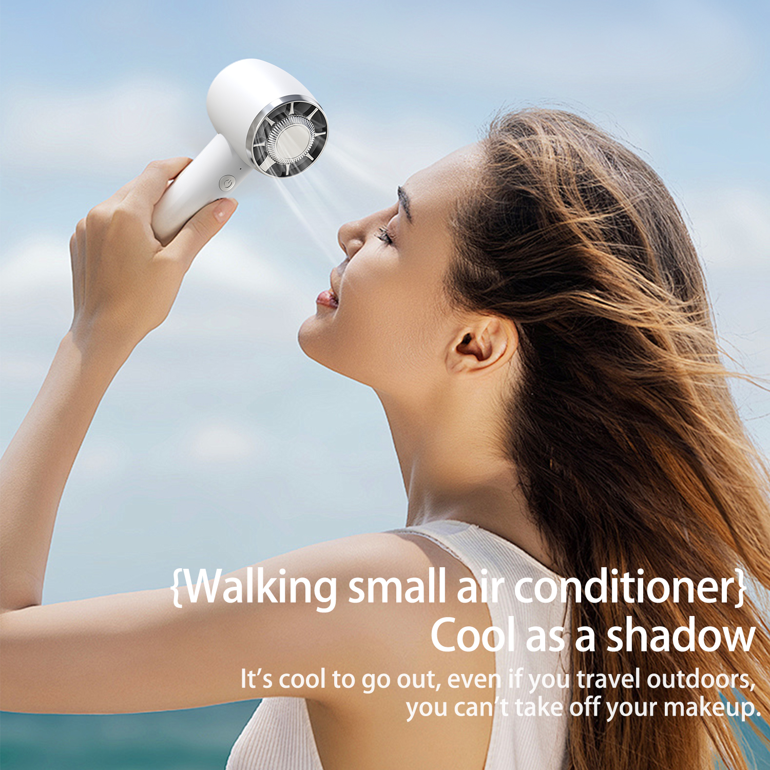 Woman using a white handheld air conditioner in front of a blue sky.