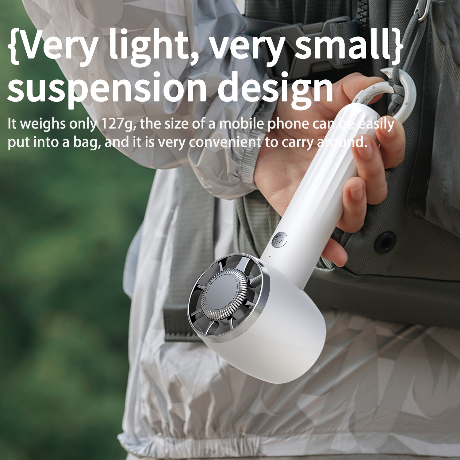 A white fan held by a person, the text mentions it is light and small. The background is a backpack.