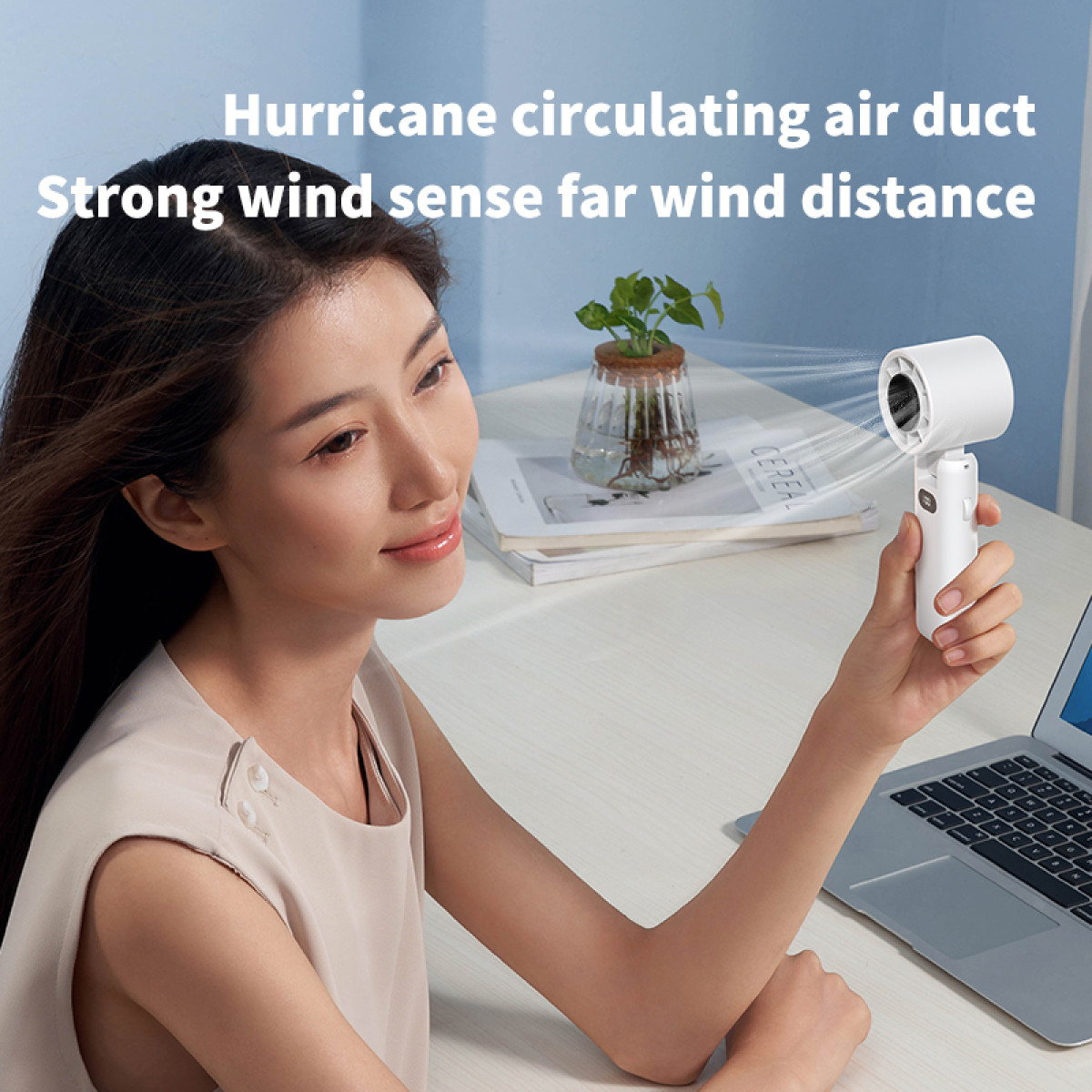 Woman holding a white portable fan. Text states: Hurricane circulating air duct. Strong wind sense.