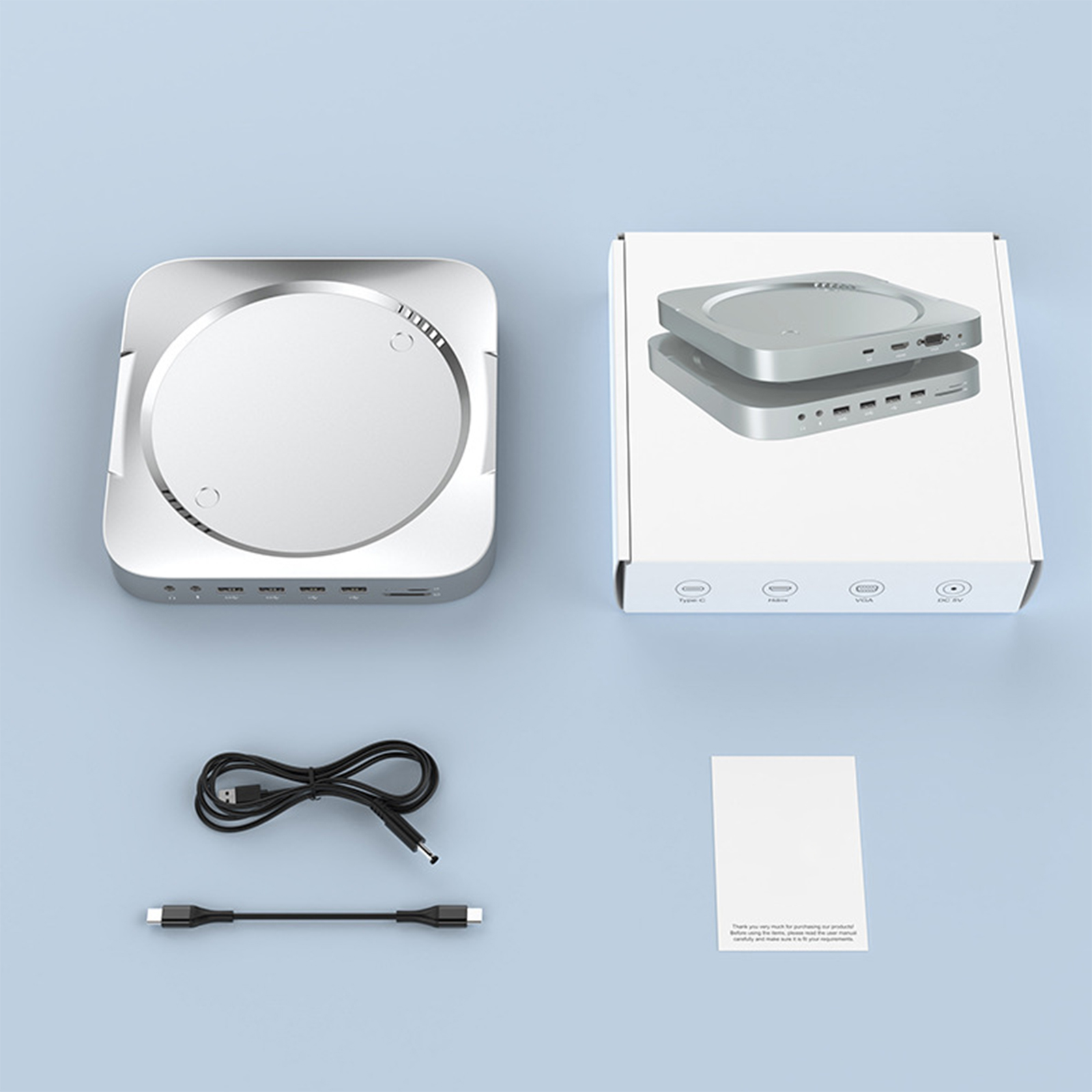 Silbernes Gerät mit Box, Kabel und Papier auf Blau. Gerät hat Anschlüsse und silbernen Deckel.