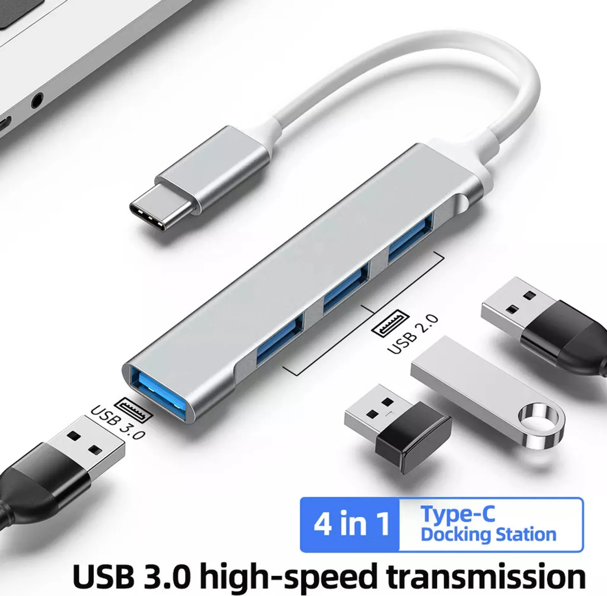Ein silberner USB-Hub mit vier Anschlüssen, verbunden mit einem USB 3.0-Kabel, zusammen mit USB-Laufwerken und einem Laptop.