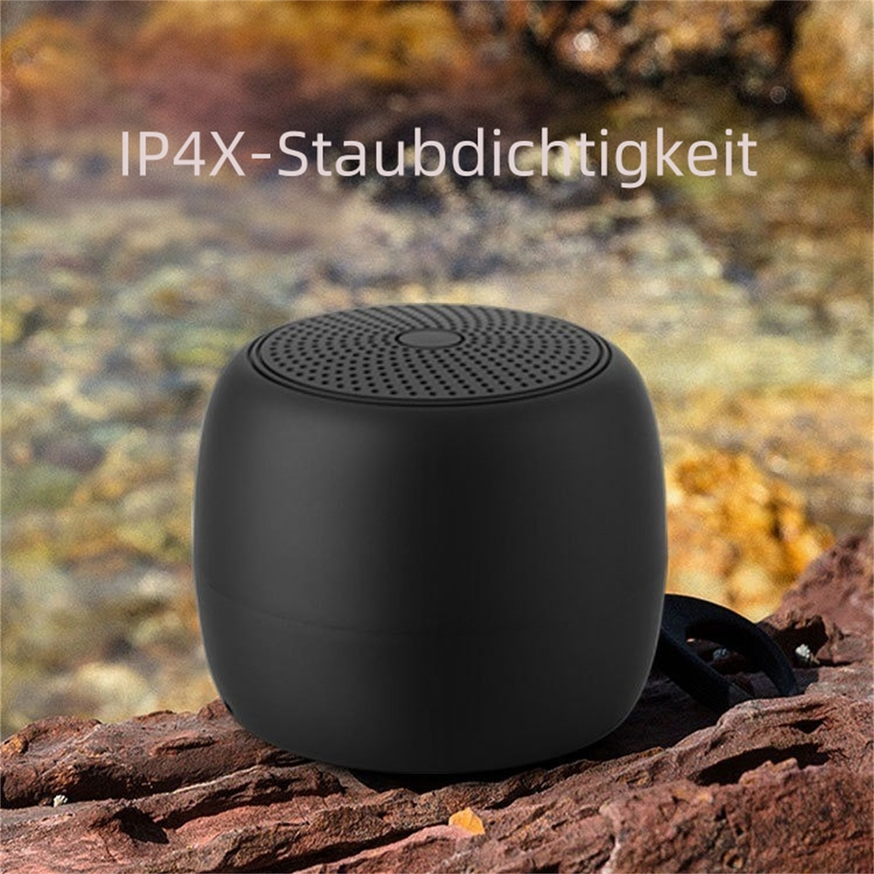 Schwarzer, zylindrischer Lautsprecher auf rauer, brauner Oberfläche. Text: IP4X-Staubdichtigkeit.
