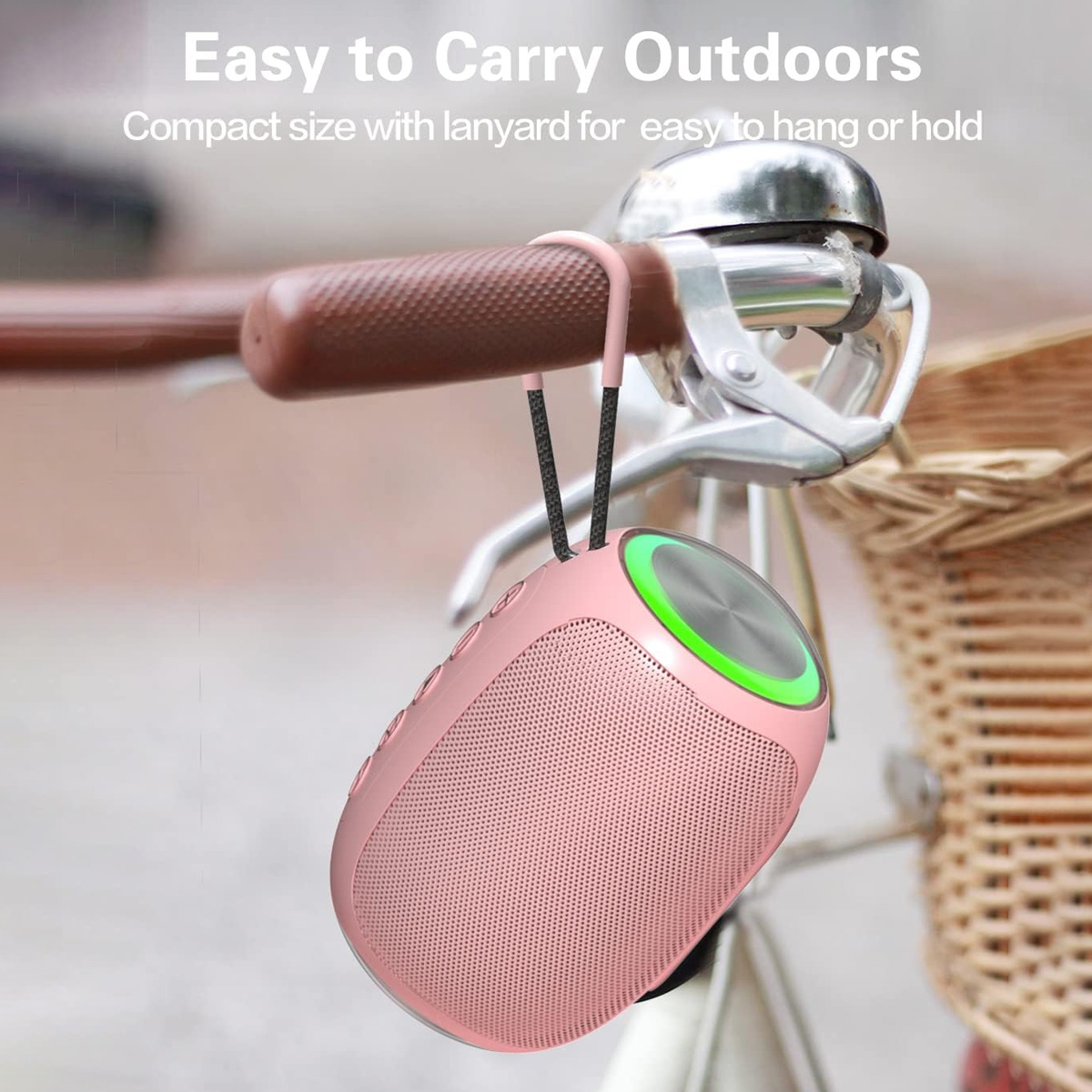 Ein rosa tragbarer Lautsprecher hängt an einem Fahrradlenker, mit grünem Licht und Lanyard.