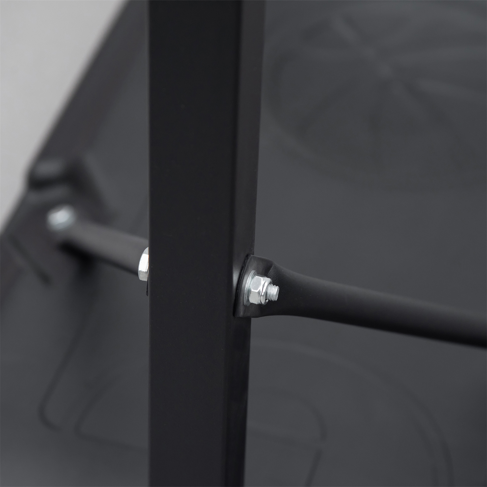 Nahaufnahme einer schwarzen Metall-Tragstruktur mit horizontaler Stange und Schraube.