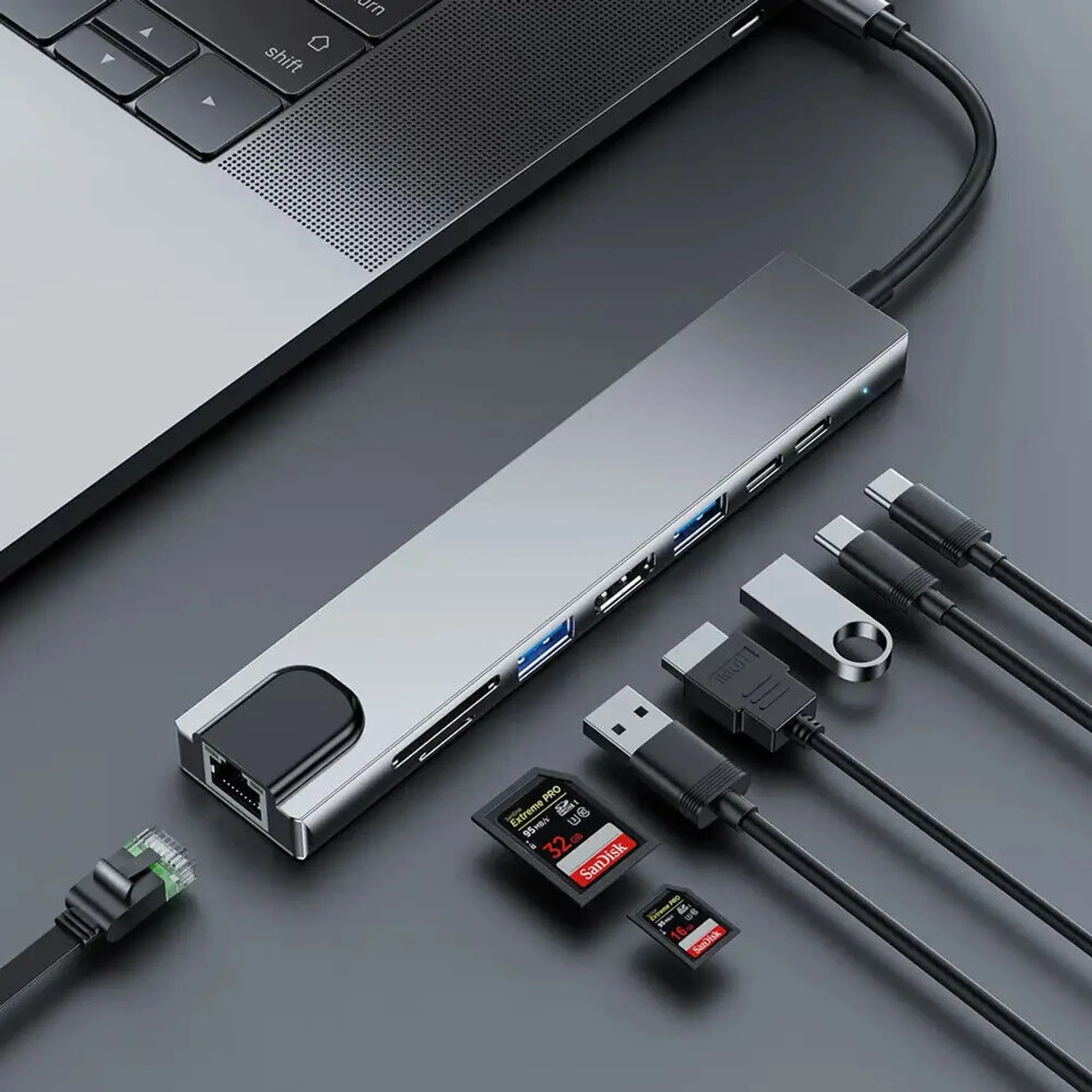 Ein silberner USB-Hub mit mehreren Anschlüssen, der an einen Laptop und andere Geräte angeschlossen ist.