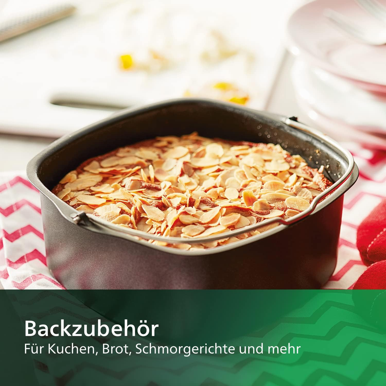 Kuchen in Backform, mit Mandeln belegt. Hintergrund zeigt Küchenumgebung.
