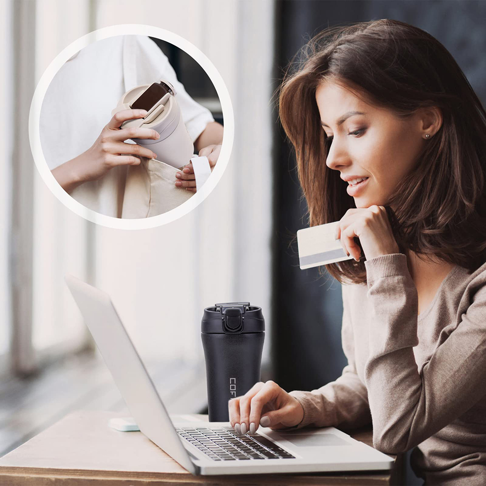 Frau am Laptop mit einem schwarzen Reisebecher, eine andere Person legt einen Becher in eine Tasche.