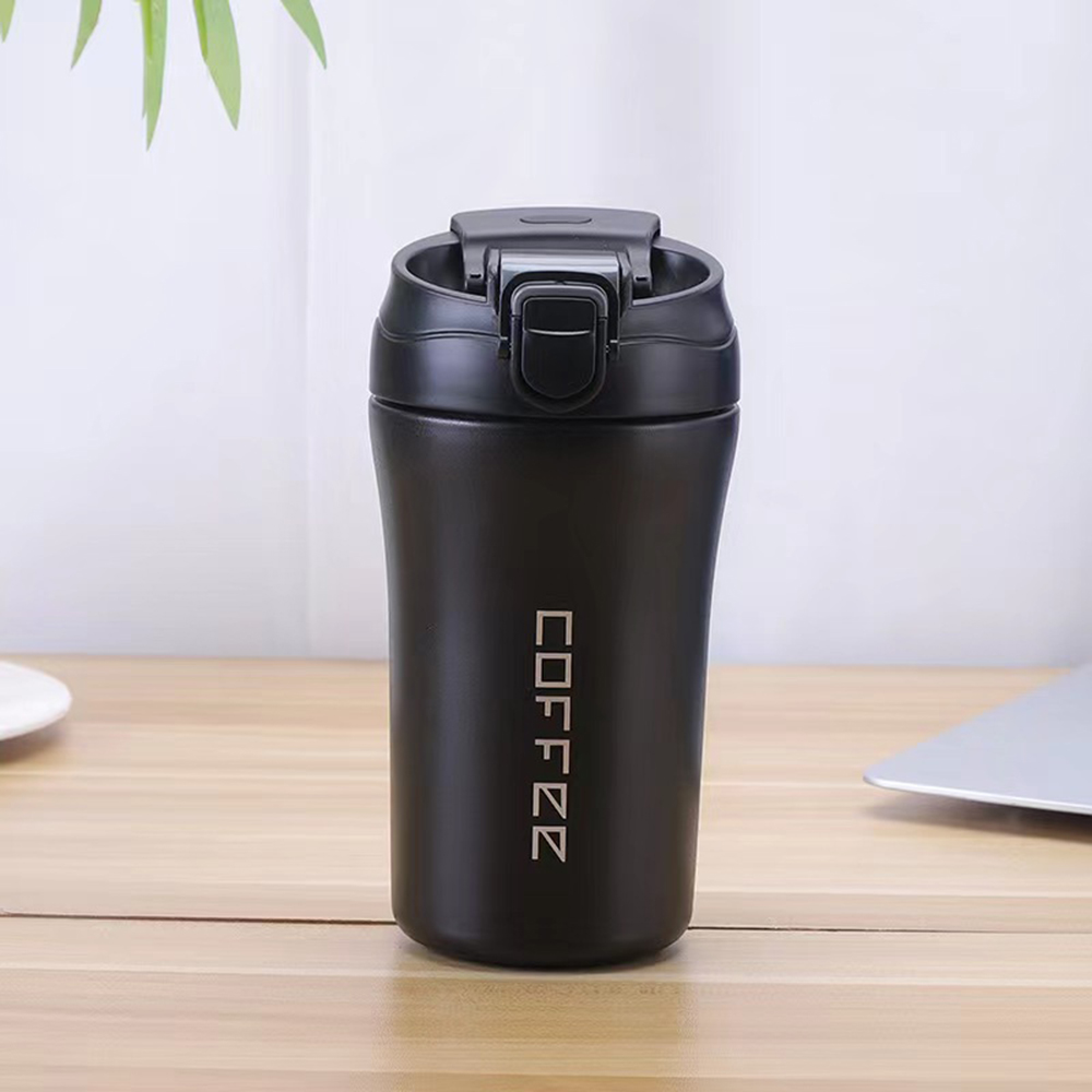 Schwarzer Kaffeebecher mit dem Wort "COFFEE" in Weiß auf einem Holztisch.