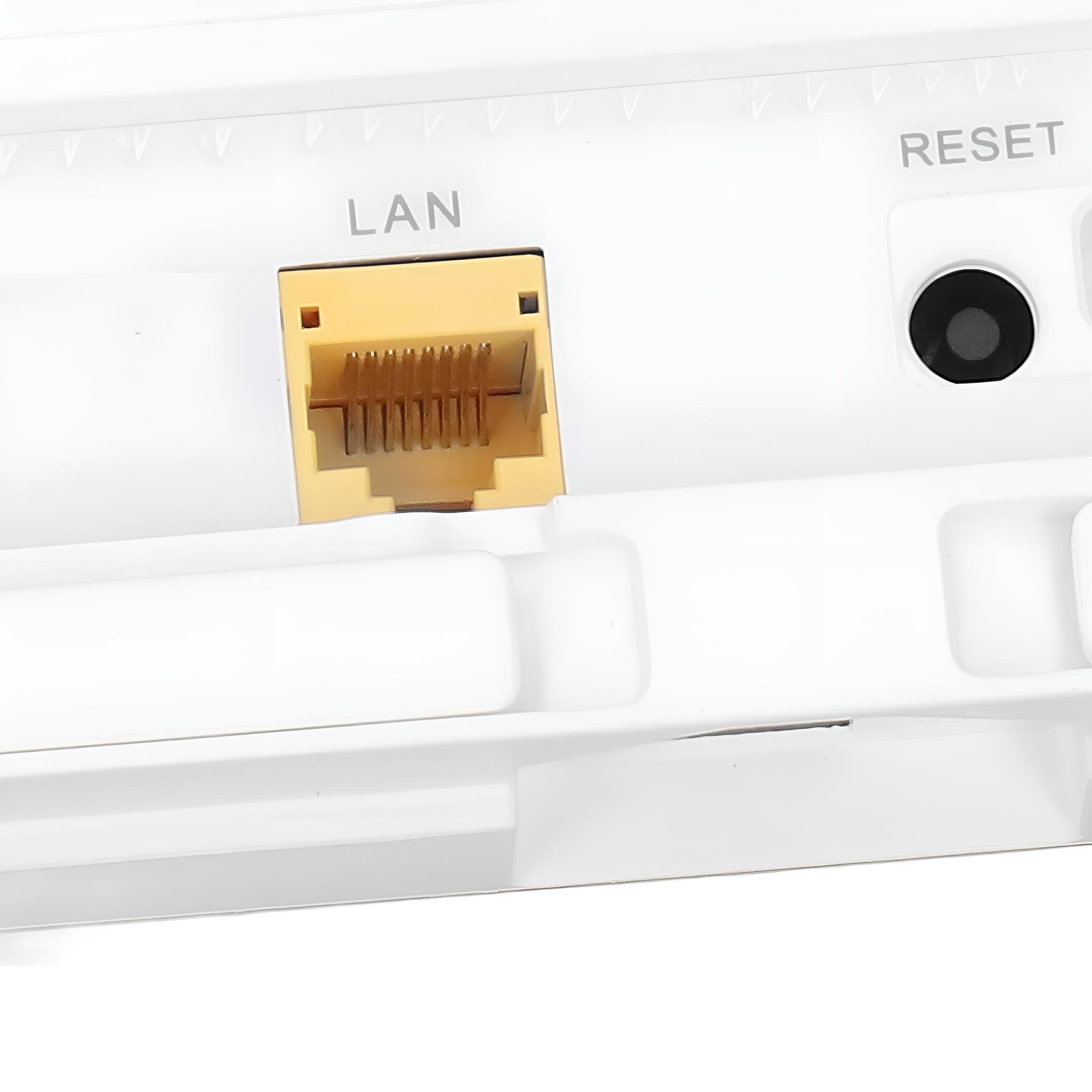 Nahaufnahme der Rückseite eines weißen Geräts mit einem LAN-Anschluss und einer RESET-Taste.