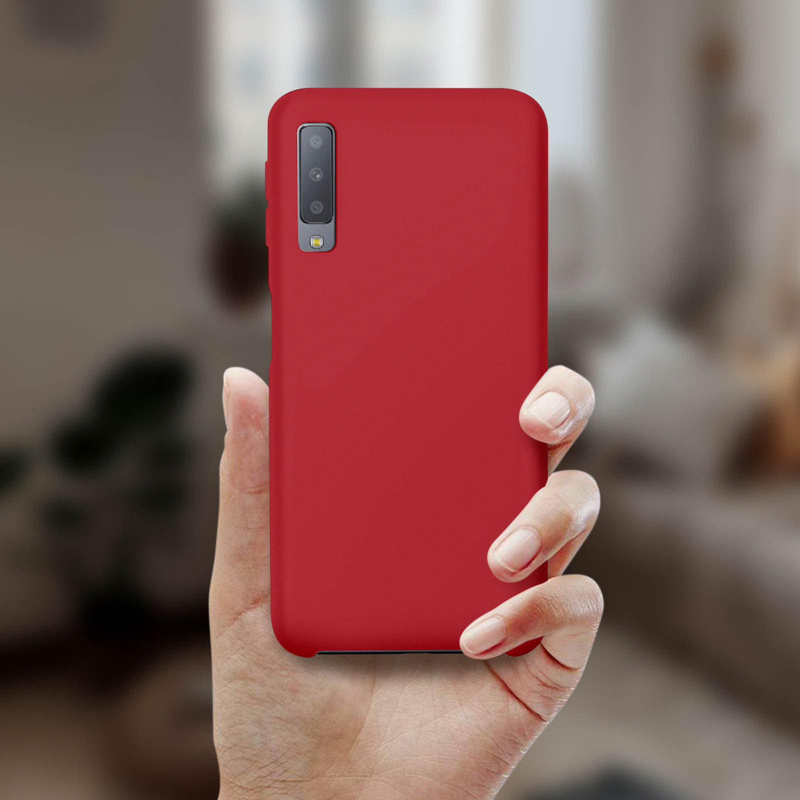 Hand, die ein rotes Telefon mit Kamera hält.