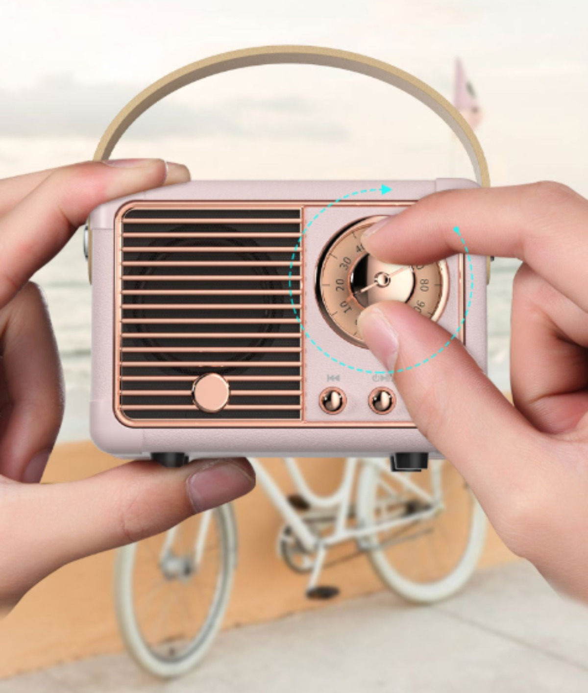 Person stellt den Drehknopf an einem rosa Vintage-Radio ein.