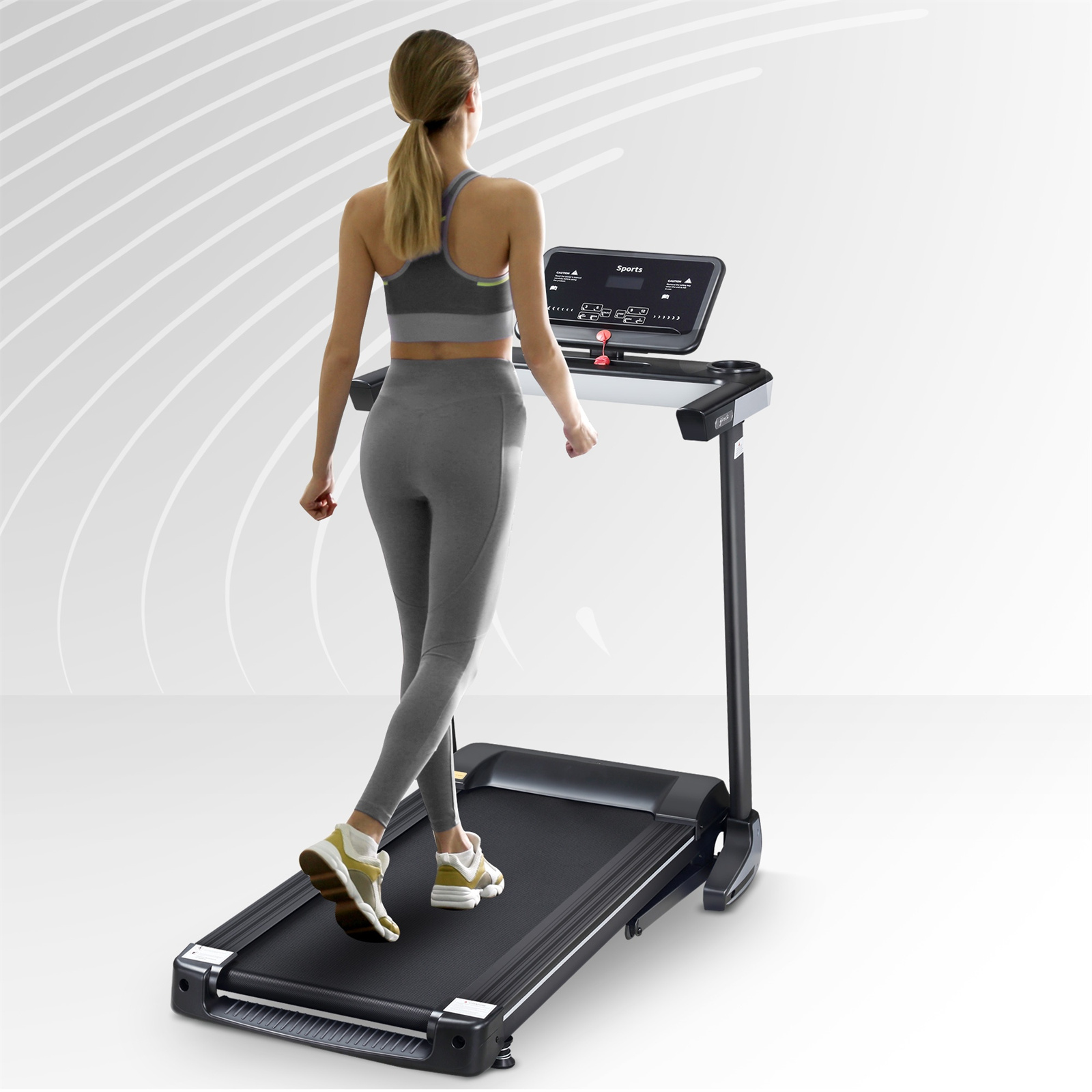 Eine Frau geht auf einem Laufband. Sie trägt Sportkleidung und schaut nach vorne. Die Maschine hat ein digitales Display.