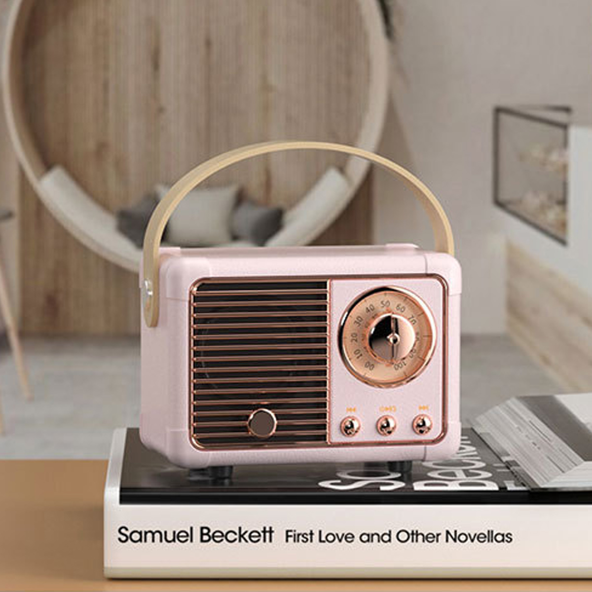 Ein rosa Retro-Radio mit Griff steht auf einem schwarzen Buch. Das Buch trägt den Titel 'Samuel Beckett'.