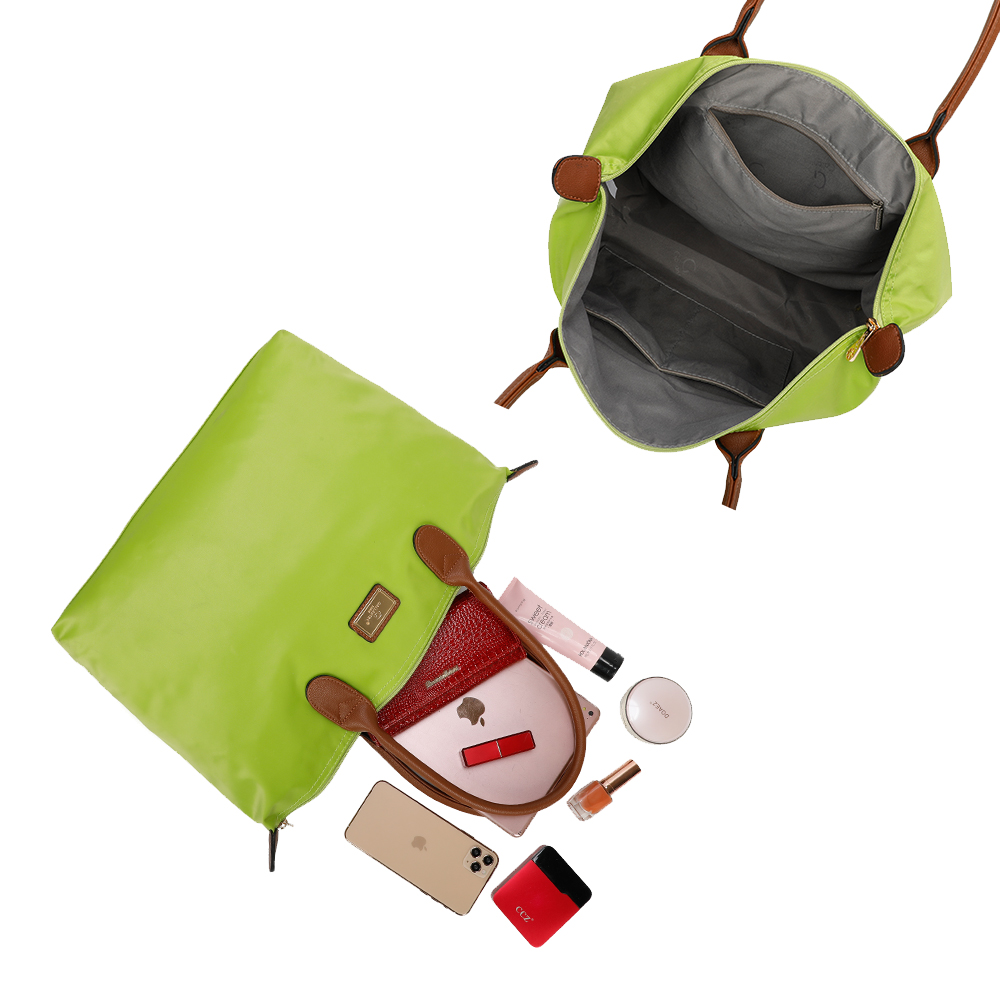 Bolso tote verde con asas marrones. El contenido incluye cosméticos, teléfono y una cartera.