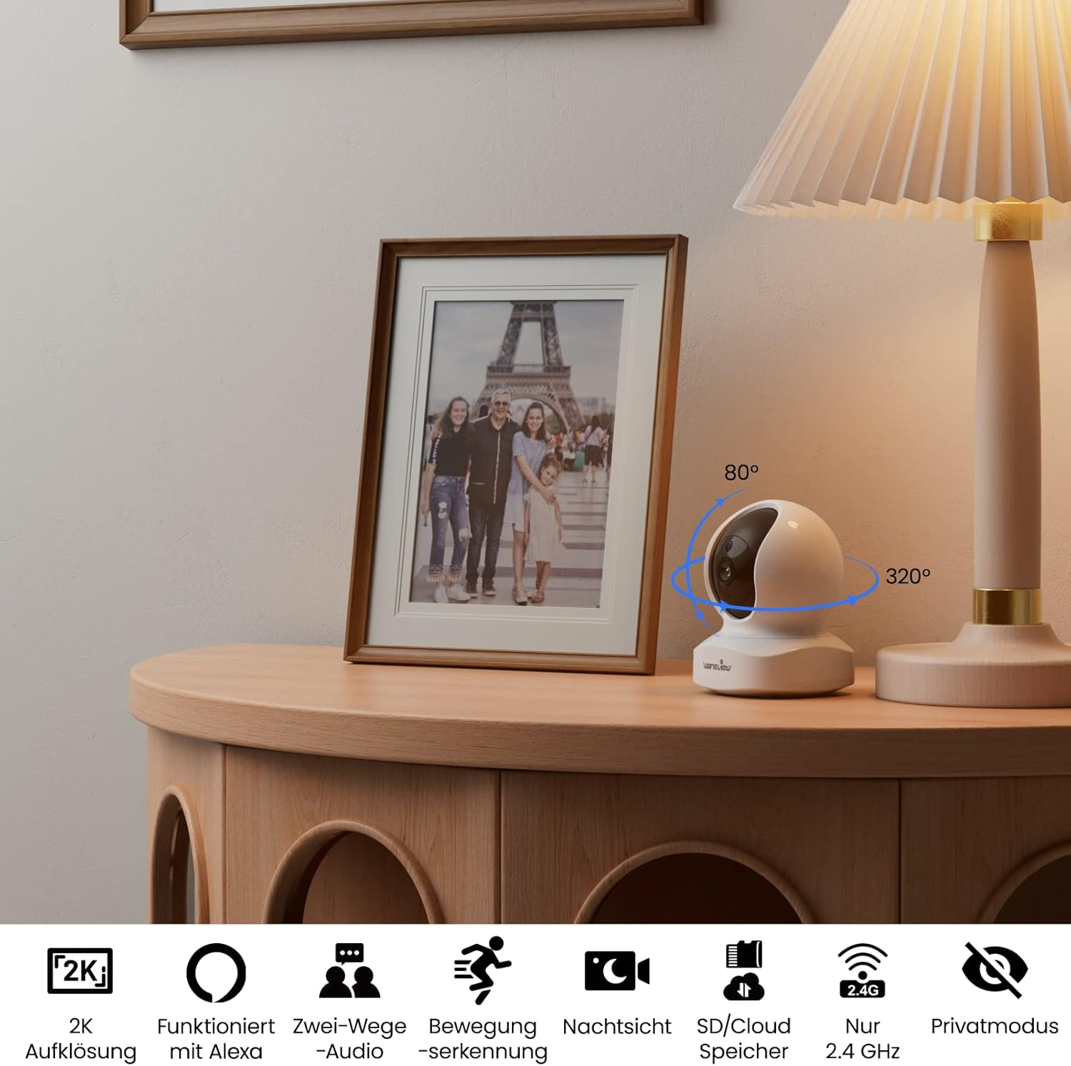 Sicherheitskamera auf einem Holztisch mit Familienfoto. Text beschreibt Funktionen: Audio, Nachtsicht.